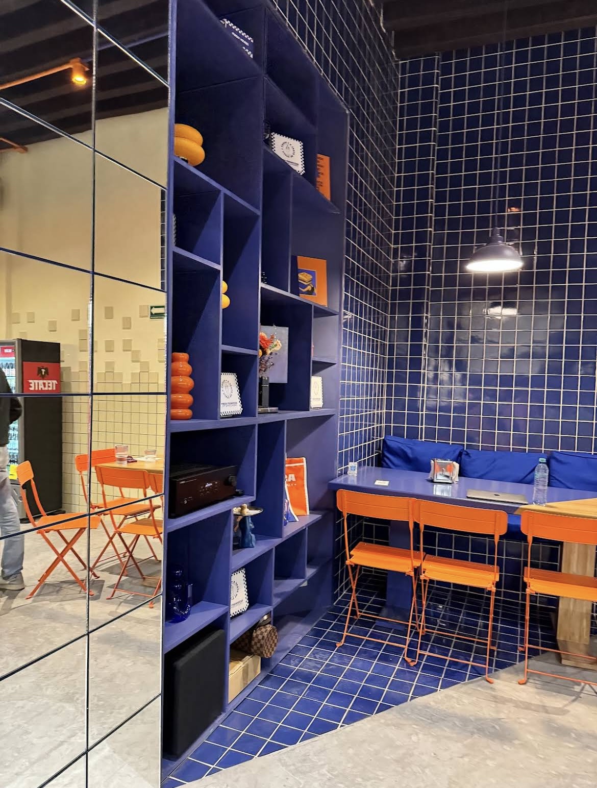Interior con repisas azules y sillas naranjas