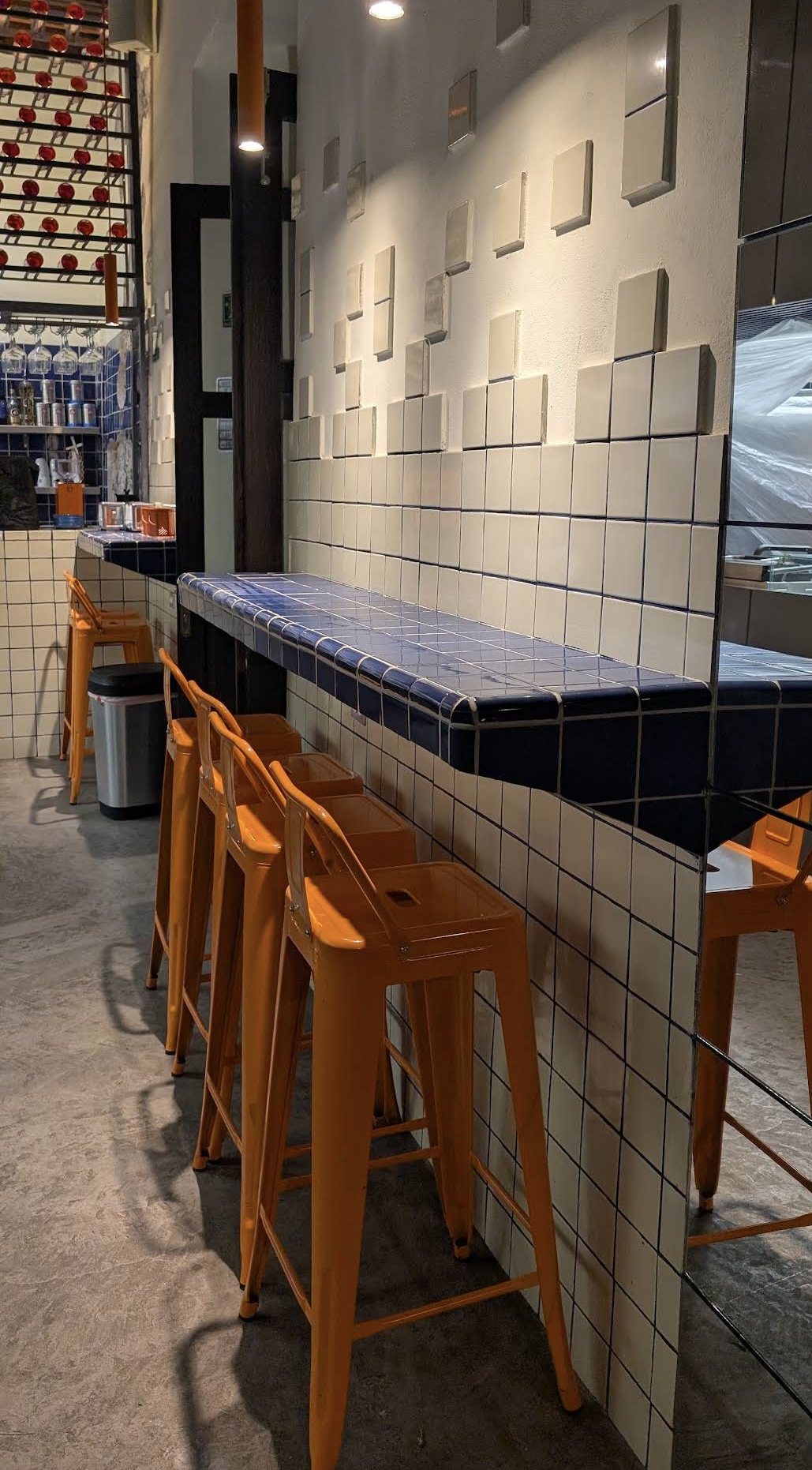 Bancos naranjas en barra de azulejos